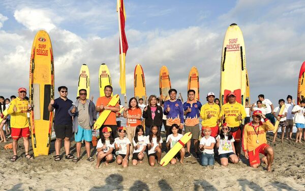 Youth participating in a lifesaving training session on the beach.